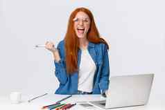 兴奋并好看的红色头发的人女学生通过了挑战发现最后考试评级在线移动PC持有笔尖叫幸福的站白色背景