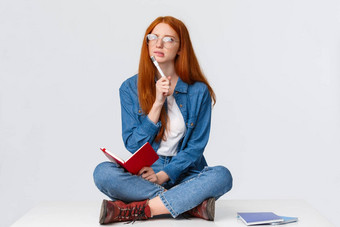 集中深思熟虑的有<strong>创意</strong>的年轻的女天才红色的头发眼镜困惑思考解决方案任务写作家庭作业坐着<strong>地板</strong>上笔记本笔