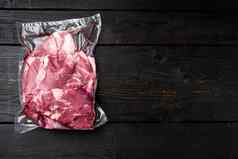 新鲜的有机肉羊肉羊肉真空包装黑色的木表格背景前视图平躺复制空间文本