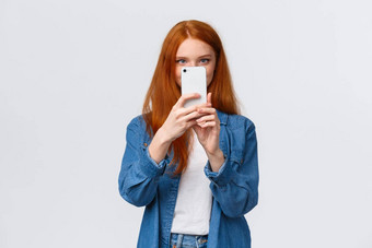 把照片过滤器快乐的可爱的女红色头发的人生活方式博主采取图片智能手机持有移动电话脸采取好拍摄搜索漂亮的角白色背景