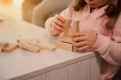 特写镜头婴儿女孩手建筑木结构块砖细电动机技能发展教育董事会游戏概念复制空间