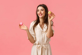 漂亮的年轻的女企业家开始业务烘焙甜点建议朋友持有马卡龙微笑快乐左逗乐站粉红色的背景很高兴