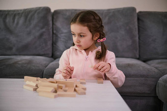 教育发展细电动机技能发展董事会游戏概念可爱的欧洲女孩集中建筑木块坐着表格生活房间