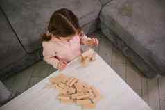 前视图有创意的学前教育孩子集中婴儿女孩建筑木块砖教育董事会游戏发展聪明的消遣细电动机技能发展概念