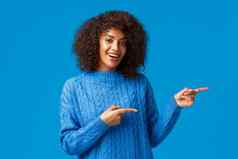 嘿访问网站快乐的快乐非裔美国人女冬天毛衣邀请退房假期价格特殊的折扣指出手指一边微笑蓝色的背景