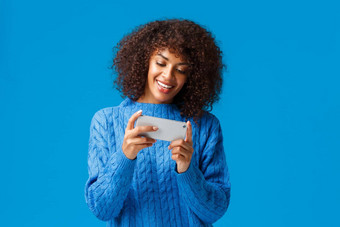快乐的快乐微笑年轻的非洲美国女人玩智能手机<strong>游戏</strong>持有移动电话水平通过比赛水平汽车<strong>游戏站</strong>蓝色的背景