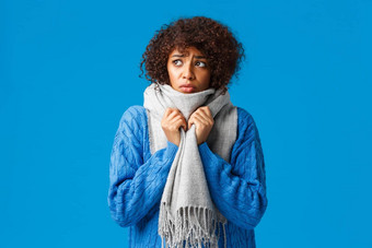 愚蠢的伤心悲观的非裔美国人女孩多风的雪天气冬天包装脖子温暖的围巾颤抖冷感觉不舒服低温度首页蓝色的背景