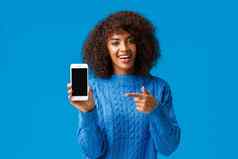 检查快乐有魅力的非裔美国人女人非洲式发型发型持有智能手机显示移动屏幕指出显示促进应用程序购物应用程序游戏