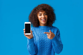 检查快乐有魅力的非裔美国人女人非洲式发型发型持有智能手机显示移动屏幕指出显示促进应用<strong>程序</strong>购物应用<strong>程序游戏</strong>