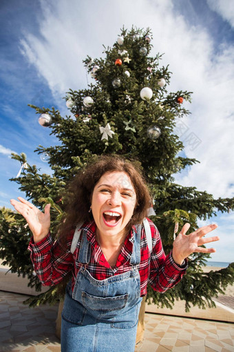 圣诞节假期幽默人概念年轻的快乐女人有趣的圣诞节树