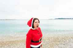圣诞节假期概念有趣的女人圣诞老人老人服装风扇海背景