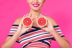 关闭年轻的女人粉红色的背景持有减少橙色手笑着说颜色痴迷概念