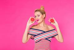 年轻的女人粉红色的背景持有减少橙色手笑着说颜色痴迷概念