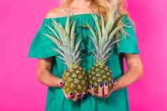 特写镜头女人菠萝粉红色的背景夏天饮食健康的生活方式概念