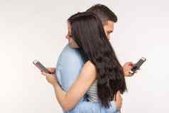 智能手机上瘾概念年轻的夫妇拥抱打字手机