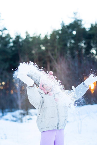 可爱的十几岁的女孩有趣的玩雪球准备好了扔雪球