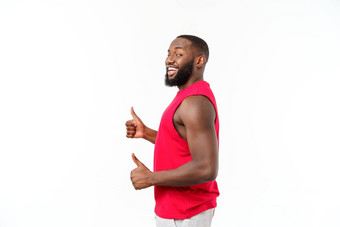 年轻的非洲美国男人。孤立的背景穿体育运动穿微笑快乐脸拇指