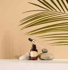 棕色（的）玻璃瓶吸管棕色（的）标签站石头容器化妆品血清石油棕榈叶影子