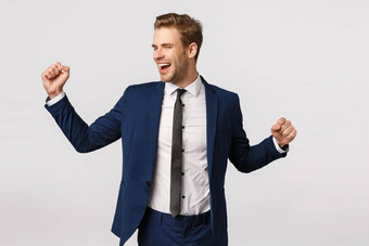 成功企业家企业概念有吸引力的快乐的商人经典西装提高手拳头泵跳舞庆祝并微笑实现目标