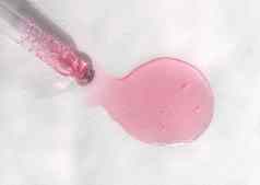 吸管粉红色的流体透明质酸酸白色背景化妆品医疗保健概念特写镜头