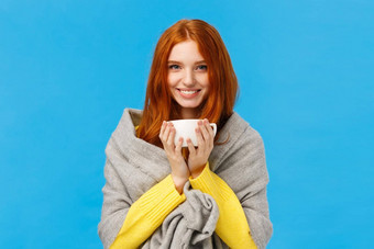 冬天假期人情绪概念快乐的可爱的浪漫的红色头发的人女人首页气候变暖热茶微笑包装灰色围巾站蓝色的背景