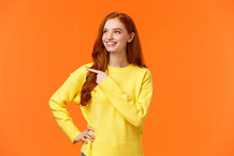 梦幻精力充沛好看的红色头发的人女黄色的毛衣发现优秀的假期礼物消费者指出左满意微笑挑选产品使决定橙色背景