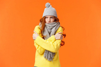 冻结冷可爱的红色头发的人女孩摇晃拥抱温暖的等待街灰色围巾冬天他雪低温度天气橙色背景