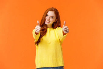 好运气乐观自信可爱的红色头发的人女朋友鼓励给竖起大拇指批准微笑率优秀的电影产品给积极的反馈推荐橙色墙