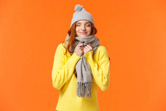 可爱的快乐红色头发的人女人走冬天假期公平市场关闭眼睛微笑闻美味的穿温暖的灰色他围巾站橙色背景