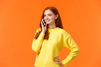 半身照肖像漂亮的红色头发的人女调用朋友谈话确认在线订单购物假期站无忧无虑的持有智能手机耳朵橙色背景