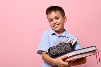 微笑学校男孩摆姿势粉红色的背景书铅笔情况下完整的文具回来学校概念面部情绪复制空间文本
