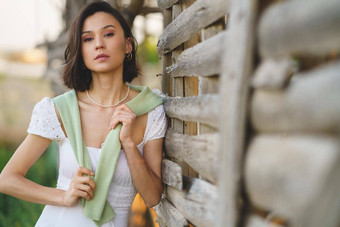 亚洲女人摆姿势烟草干燥流穿白色衣服绿色长筒靴