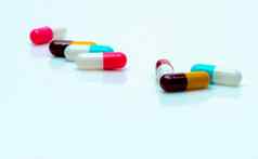 多色抗生素胶囊药片传播白色背景抗生素药物电阻抗菌胶囊药片制药行业粉红色的白色蓝色的黄色的红色的胶囊药片
