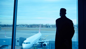 轮廓肖像商人业务旅行站全景窗口机场休息室飞机跑道等待飞行