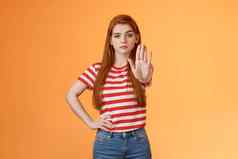 严肃的表情自信勇敢的红色头发的人女孩反对仇敌战斗自由禁止非法行动扩展手停止被禁止的手势确定相机