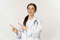 肖像微笑年轻的女人医生医疗保健医疗工人指出手指左显示诊所促销标志横幅站白色背景