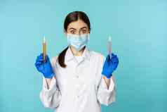 图像年轻的女人医生实验室工人研究持有测试管穿医疗脸面具橡胶手套蓝色的背景