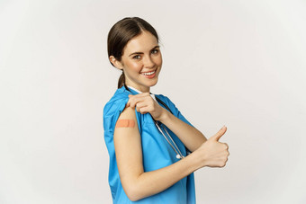 微笑护士医疗工人显示拇指肩膀疫苗科维德疫苗接种运动站白色背景实习医生风云