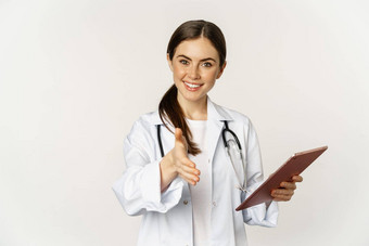 友好的年轻的女医生医生拉伸手握手问候病人诊所持有数字平板电脑医疗数据白色背景