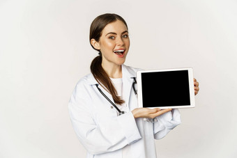在线<strong>医疗</strong>远程任命微笑美丽的女人医生显示数字平板电脑屏幕展示<strong>网站</strong>标志站白色背景