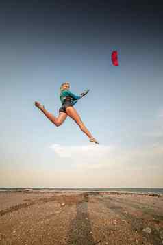 女运动员风筝冲浪者跳跃风筝海滩免费的飞行土地风筝