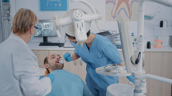 牙科团队执行牙提取口腔学内阁