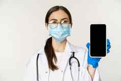 在线医疗概念女人医生眼镜脸面具显示移动电话屏幕应用程序接口网站病人站白色背景
