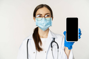 在线<strong>医疗</strong>概念女人医生眼镜脸面具显示移动电话屏幕应用程序接口<strong>网站</strong>病人站白色背景