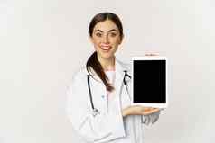 图像女人医生女医疗保健工人显示在线医疗网站数字平板电脑屏幕微笑站白色外套白色背景