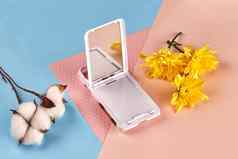 白色花棉花黄色的菊花小口袋里折叠镜子粉红色的蓝色的背景关闭复制空间