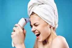 女人毛巾头清洁脸皮肤护理蓝色的背景