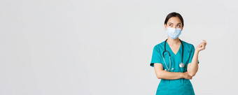 科维德冠状病毒疾病医疗保健工人概念好奇的深思熟虑的亚洲女医生医疗面具实习医生风云上左角落里思考白色背景