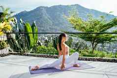 年轻的女人白色紧身裤瑜伽练习伸展运动臀部腿四胞胎