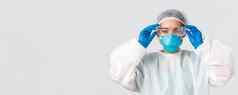 科维德冠状病毒疾病医疗保健工人概念严肃的表情亚洲女医生个人保护设备把玻璃进入实验室白色背景